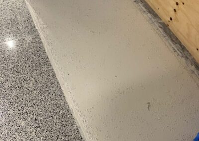 A room with a white floor and a wooden wall